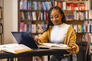 Attractive young female university student using a laptop while studying